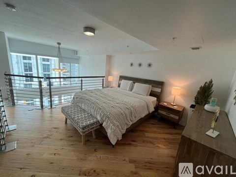 A bedroom with a large bed and a wooden floor.