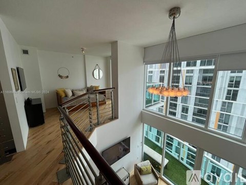 A modern living room with a balcony overlooking a cityscape.