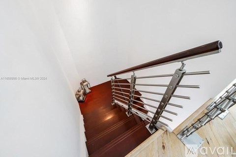 A staircase with a metal railing and wooden steps.