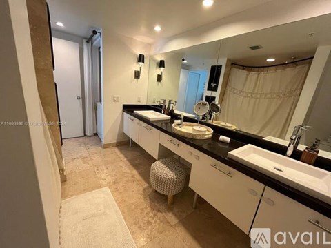 A bathroom with two sinks and a large mirror.