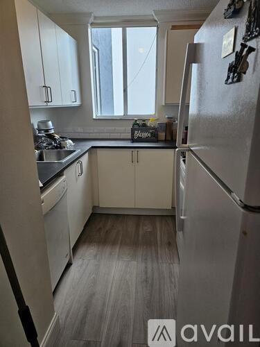 A kitchen with white appliances and cabinets.