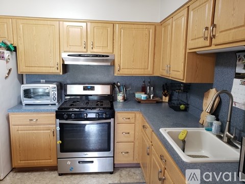 A kitchen with wooden cabinets and a black stove top oven.