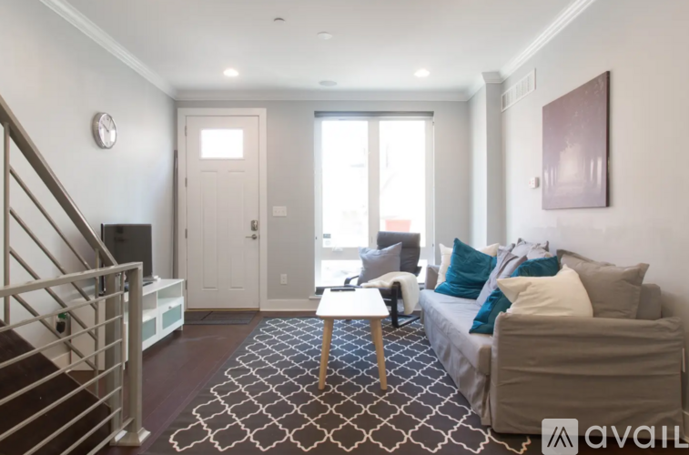 A living room with a couch, a coffee table, and a staircase.