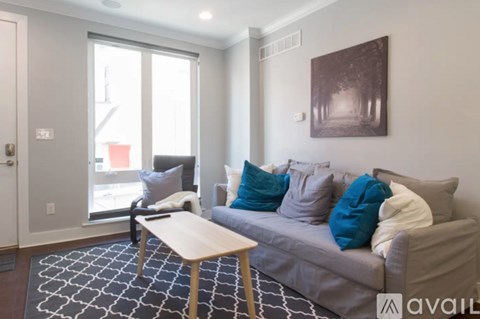 A living room with a grey couch and a wooden table.