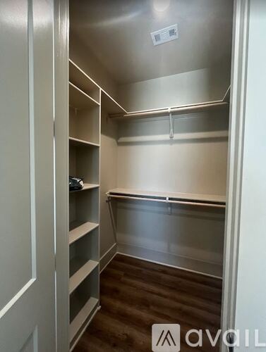 A walk-in closet with shelves and a carpeted floor.