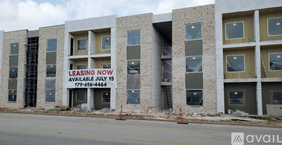 A building with a sign that says "Leasing Now Available July 15" is under construction.