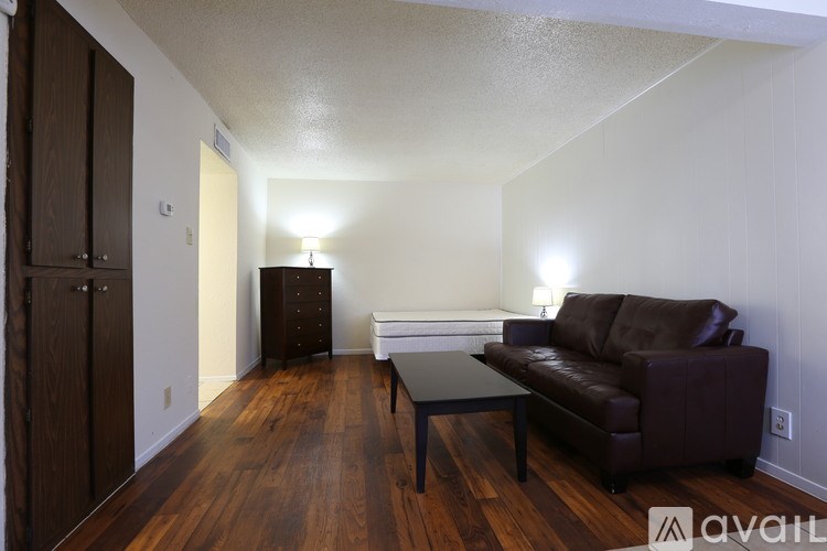 A living room with a brown couch and a wooden floor.