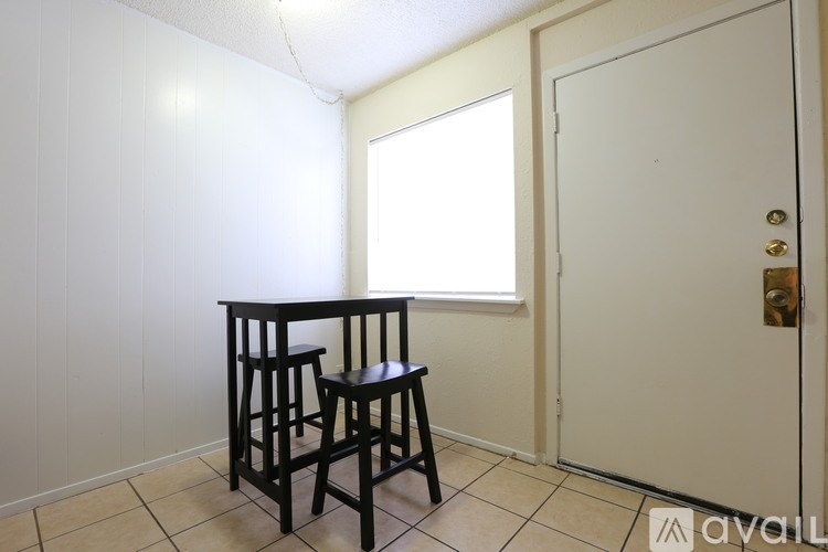 Two wooden chairs are placed in a room with a white door.