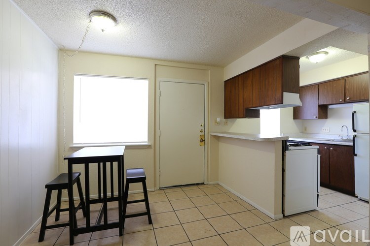 A kitchen area with a bar stool and a window.