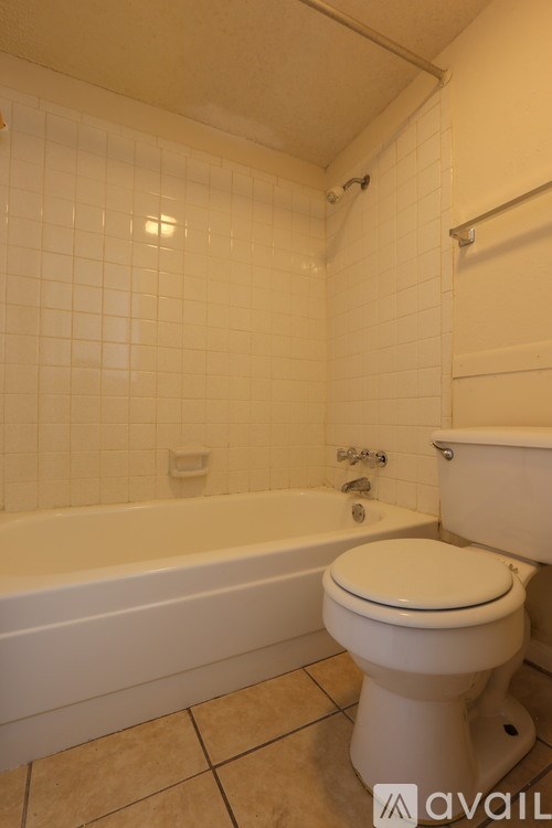 A white toilet sits next to a bathtub in a bathroom.