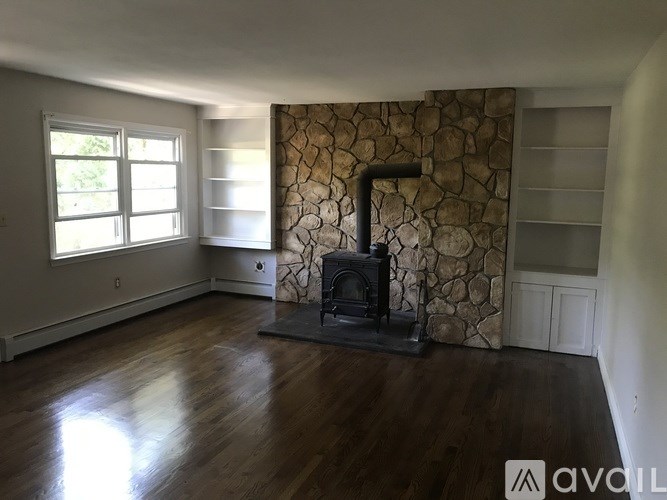 A room with a stone wall and a wood burning stove.