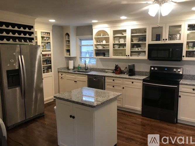 A kitchen with a granite island in the middle.