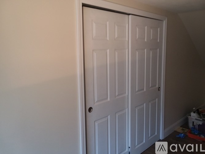 A white door with a handle is in a room.