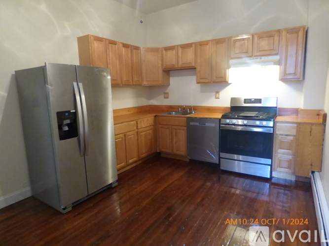 A kitchen with wooden cabinets and a stainless steel refrigerator.