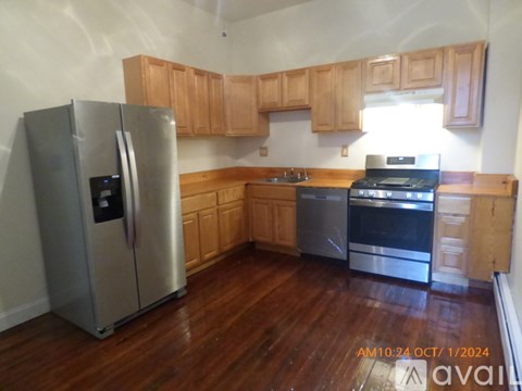 A kitchen with wooden cabinets and a stainless steel refrigerator.