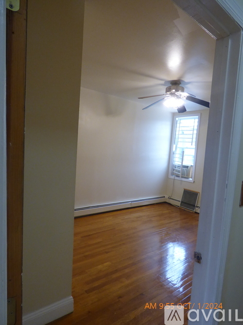 A room with a ceiling fan and a window.
