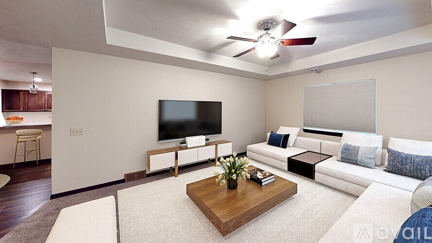 A living room with a flat screen TV and a white couch.