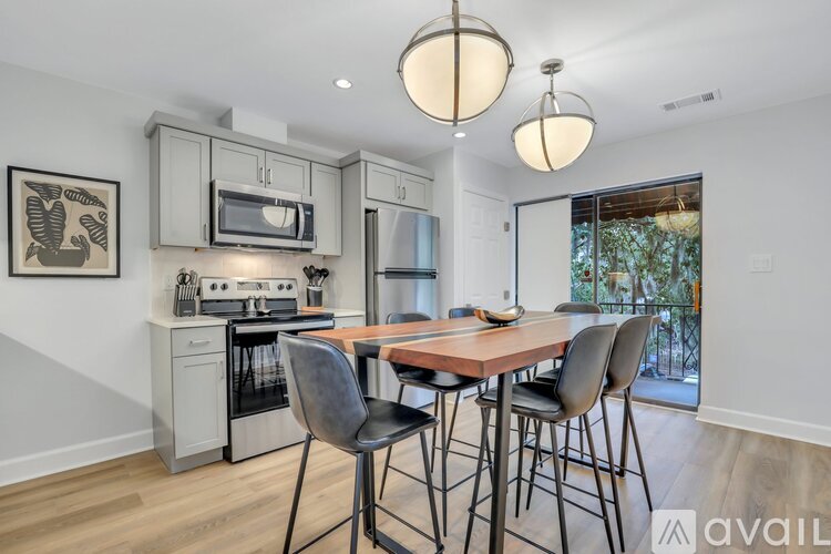 A kitchen with a dining table and chairs.