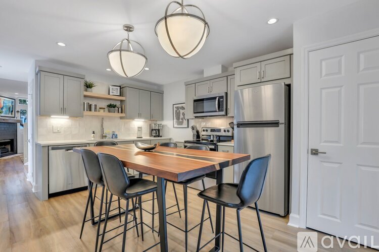 A kitchen with a table and chairs in front of a refrigerator.