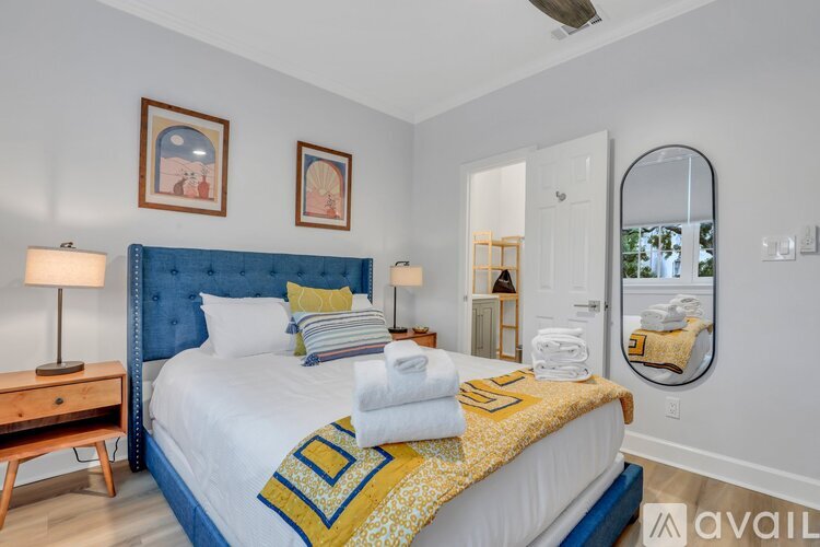 A bedroom with a blue headboard and a bed with a yellow and blue comforter.
