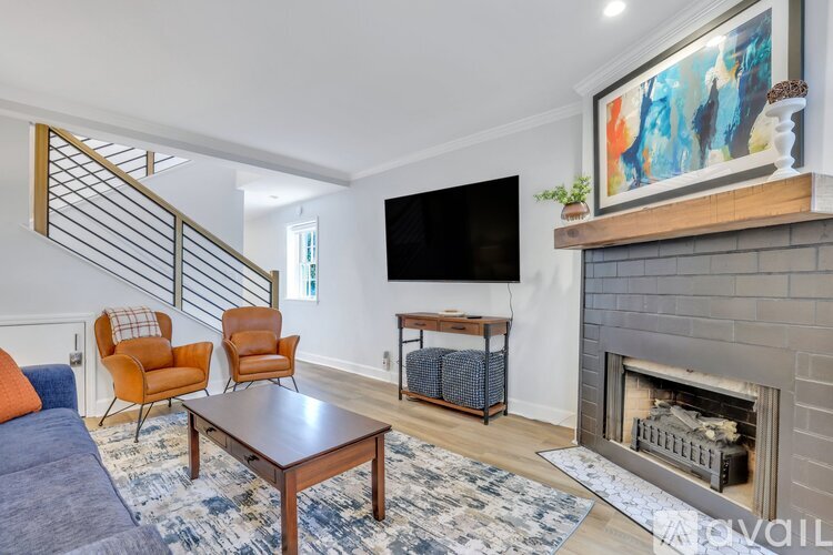 A living room with a fireplace and a painting on the wall.