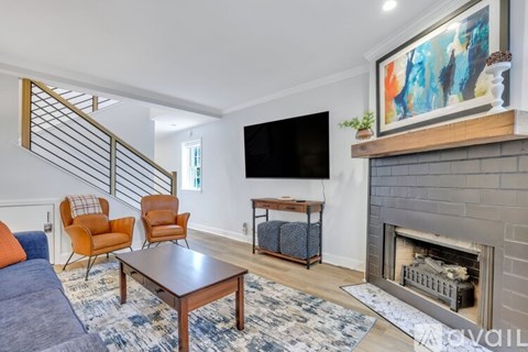 A living room with a fireplace and a painting on the wall.