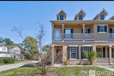 A two-story house with a balcony and multiple windows.