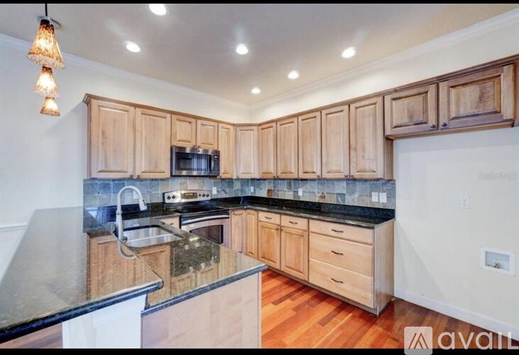 A kitchen with wooden cabinets and a black countertop.