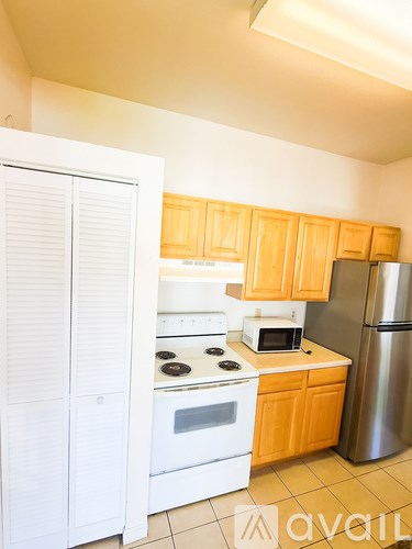 A kitchen with wooden cabinets and white appliances.