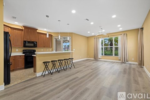 A kitchen with wooden cabinets and a black refrigerator is available.