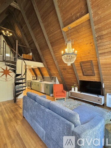 A living room with a grey couch and a wooden ceiling.