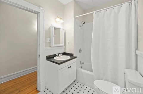 A white bathroom with a black and white tiled floor.
