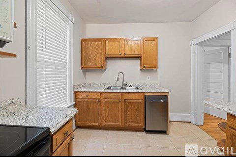 A kitchen with wooden cabinets and a granite countertop.