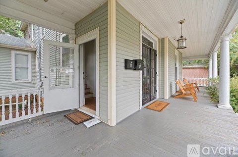 A porch with a white door and a brown mat.