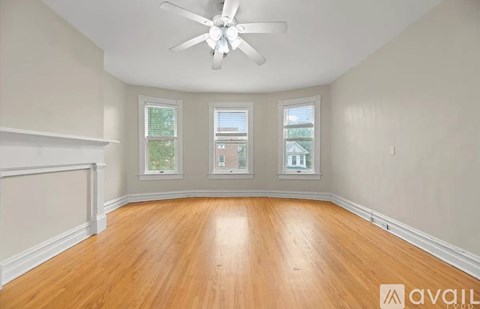 A room with wooden floors and a ceiling fan.