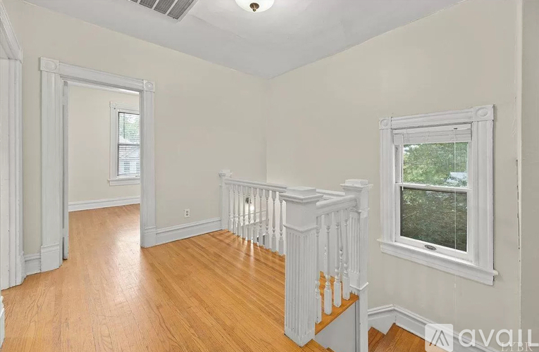 A room with a window and a wooden floor.