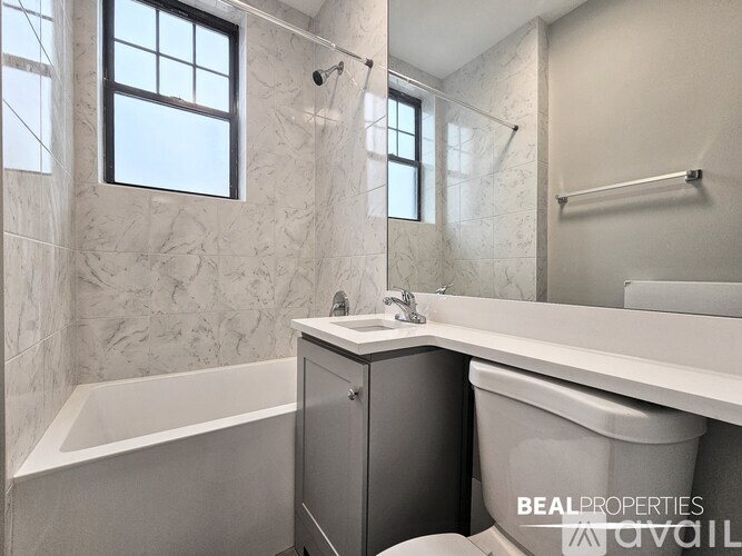 A bathroom with a tub, toilet, and sink.
