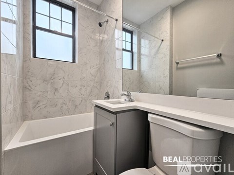 A bathroom with a tub, toilet, and sink.