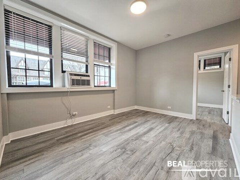 A room with a window, a door, and a wall socket.