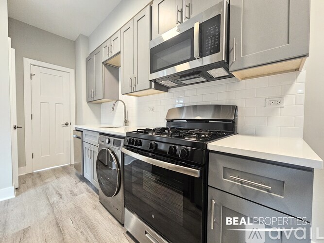 A modern kitchen with a black stove top oven and a washing machine.