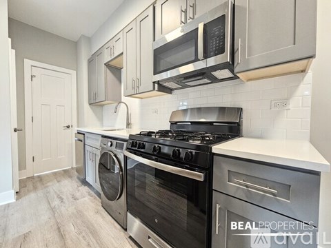 A modern kitchen with a black stove top oven and a washing machine.
