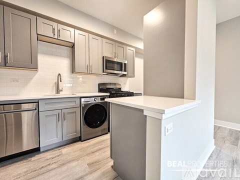A modern kitchen with stainless steel appliances and white cabinets.