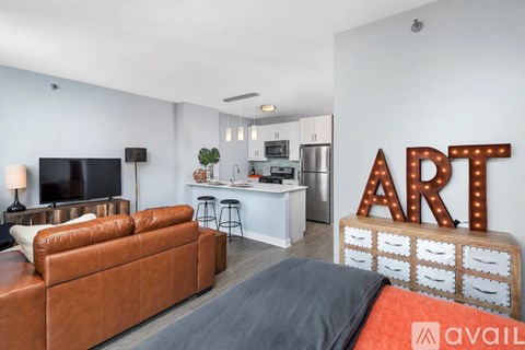 A living room with a brown leather couch and a television.