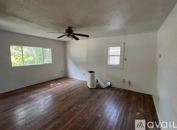A room with a ceiling fan and a window.