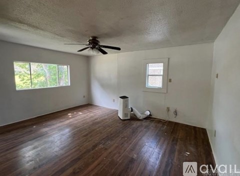 A room with a ceiling fan and a window.