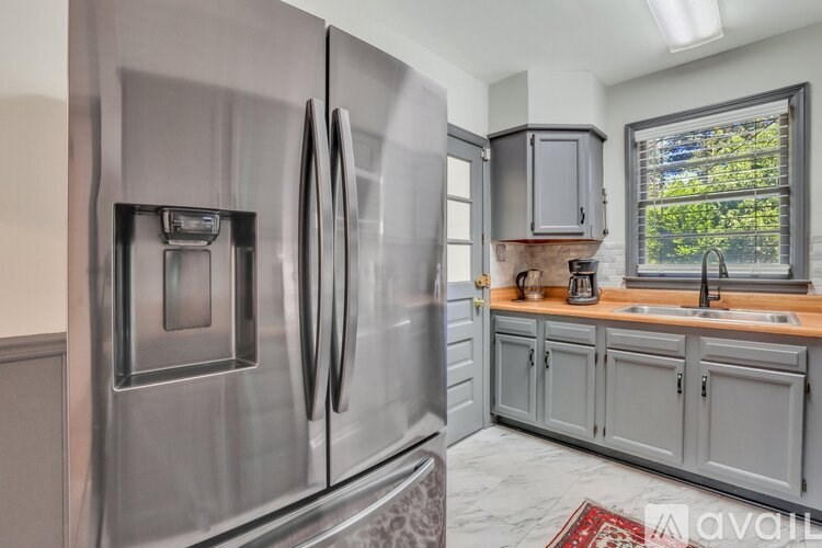 A modern kitchen with a stainless steel refrigerator and wooden countertops.