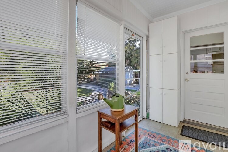 A room with a table and a window with blinds.