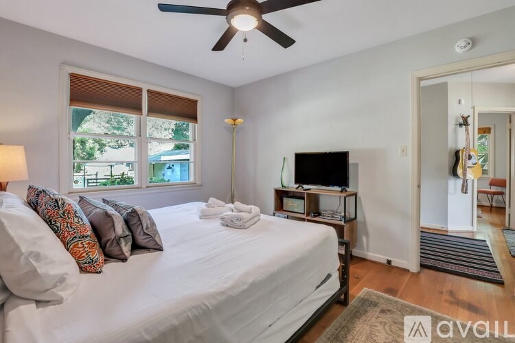 A bedroom with a large bed and a television in the corner.