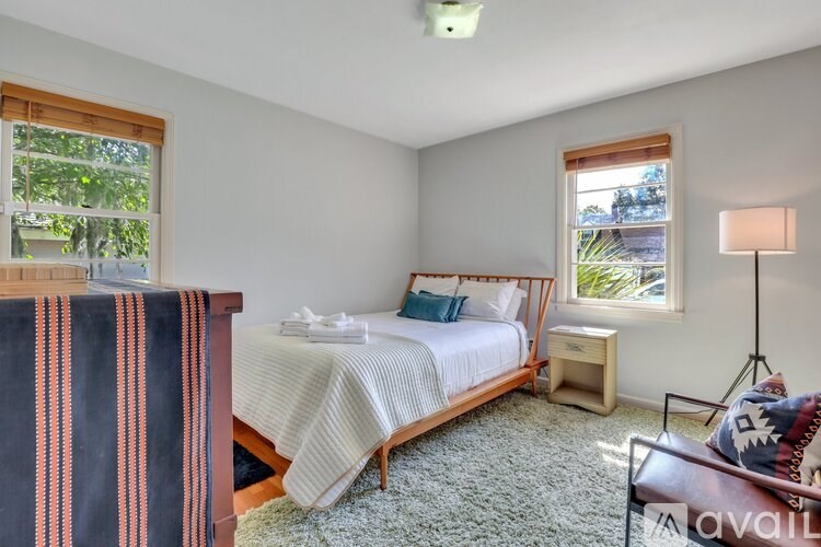 A bedroom with a bed, nightstand, and window.