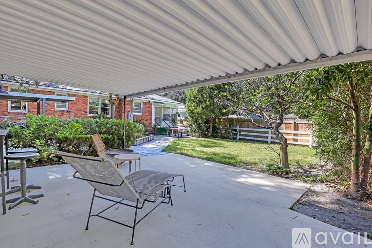 A patio with a table and chairs under a white awning.
